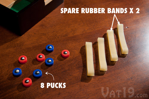 The Desktop Shuffleboard Game comes with eight pucks and four rubber bands (2 spare).