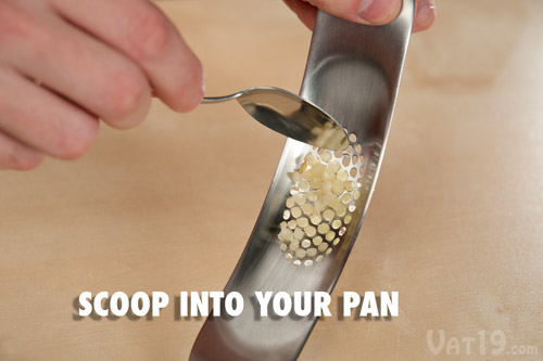 After you've crushed the garlic, scrape it into a pan with a spoon.