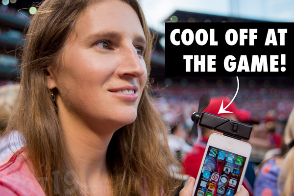 Woman cooling off at a baseball game using iPhone Fan Attachment.