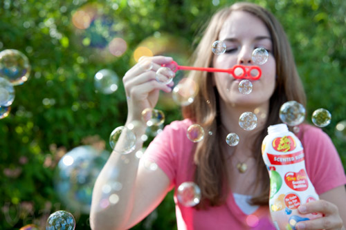 Young woman blowing Jelly Belly Scented Bubbles.