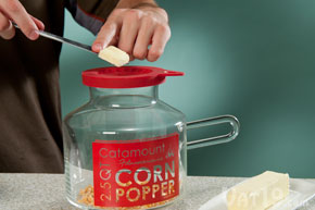 Add the desired amount of butter to the popcorn popper's melting lid.