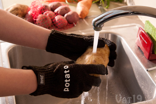 Skrub'a Gloves cleaning a potato.