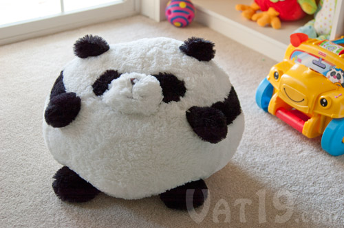 Squishables Stuffed Animal Panda sitting on a carpet.